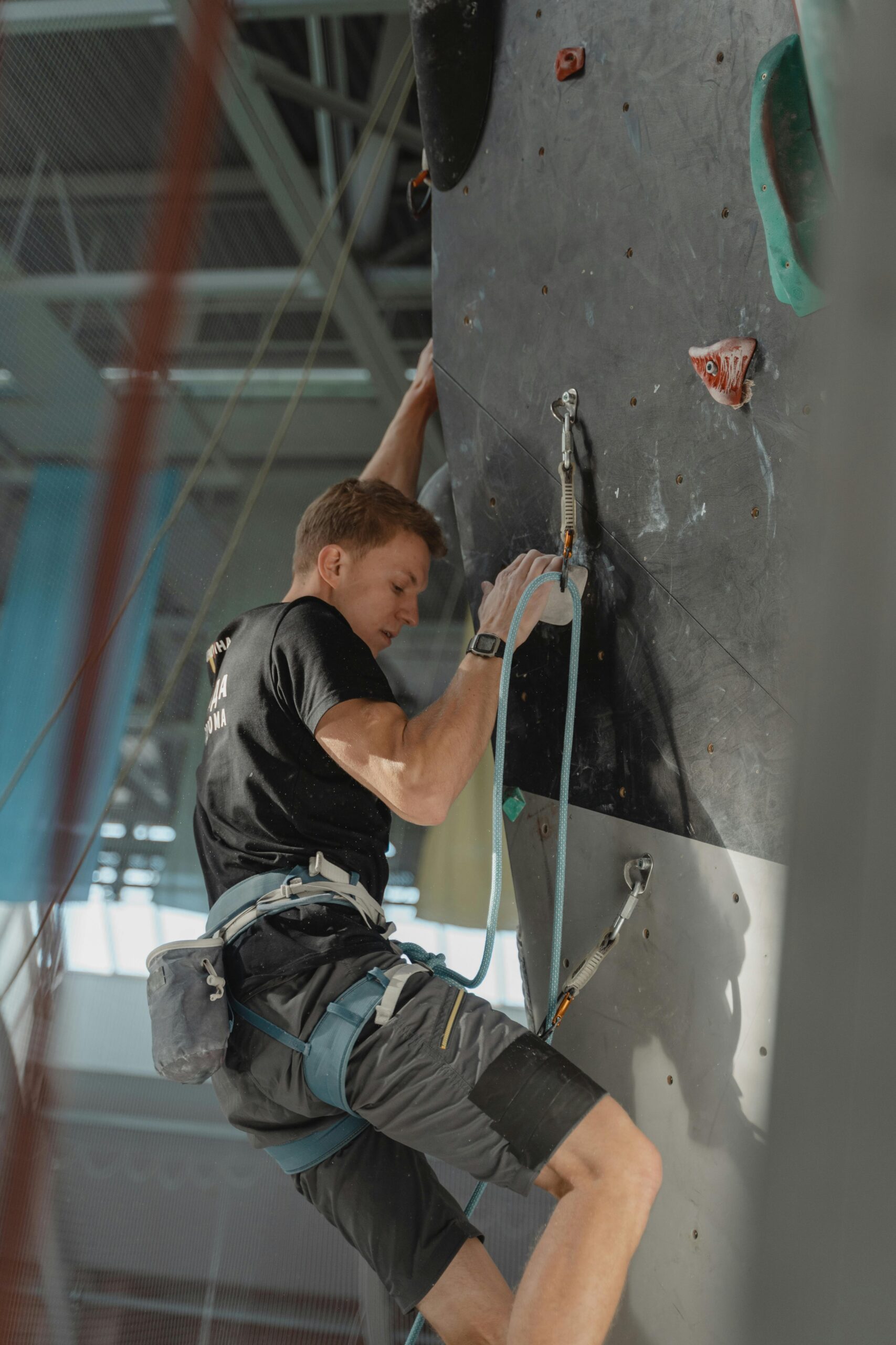 Climber training on an indoor wall, showcasing strength and focus.