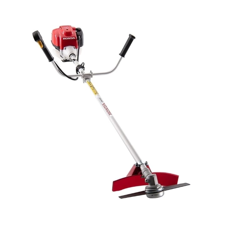 Honda UMK435 4-stroke grass cutting machine with bike handle standing on farm ground in Pakistan